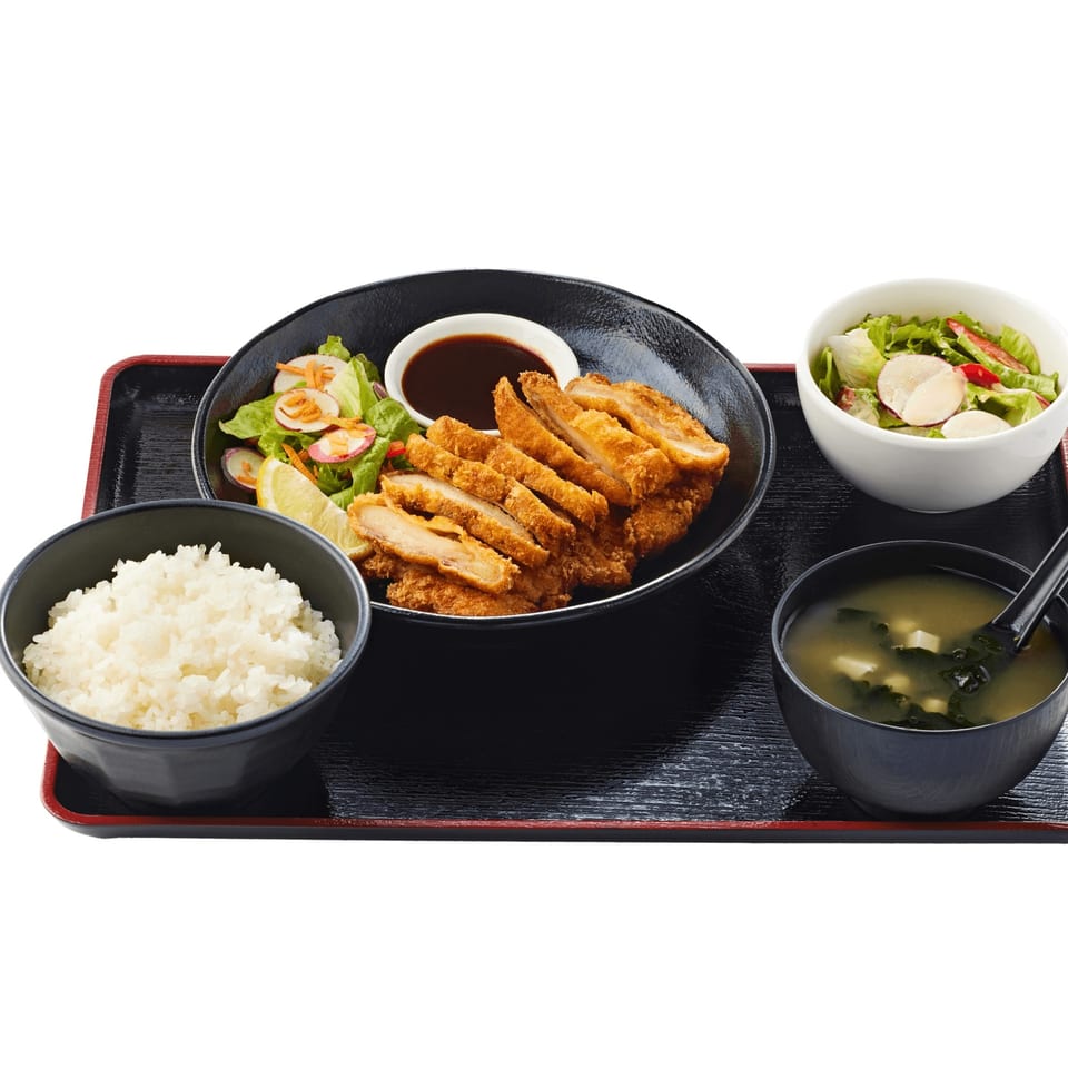 A Tonkatsu meal with crispy fried pork cutlets, rice, miso soup, and a side salad.