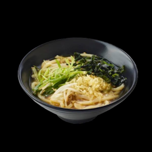 A black bowl of udon noodles with green onions, seaweed, and tempura flakes.
